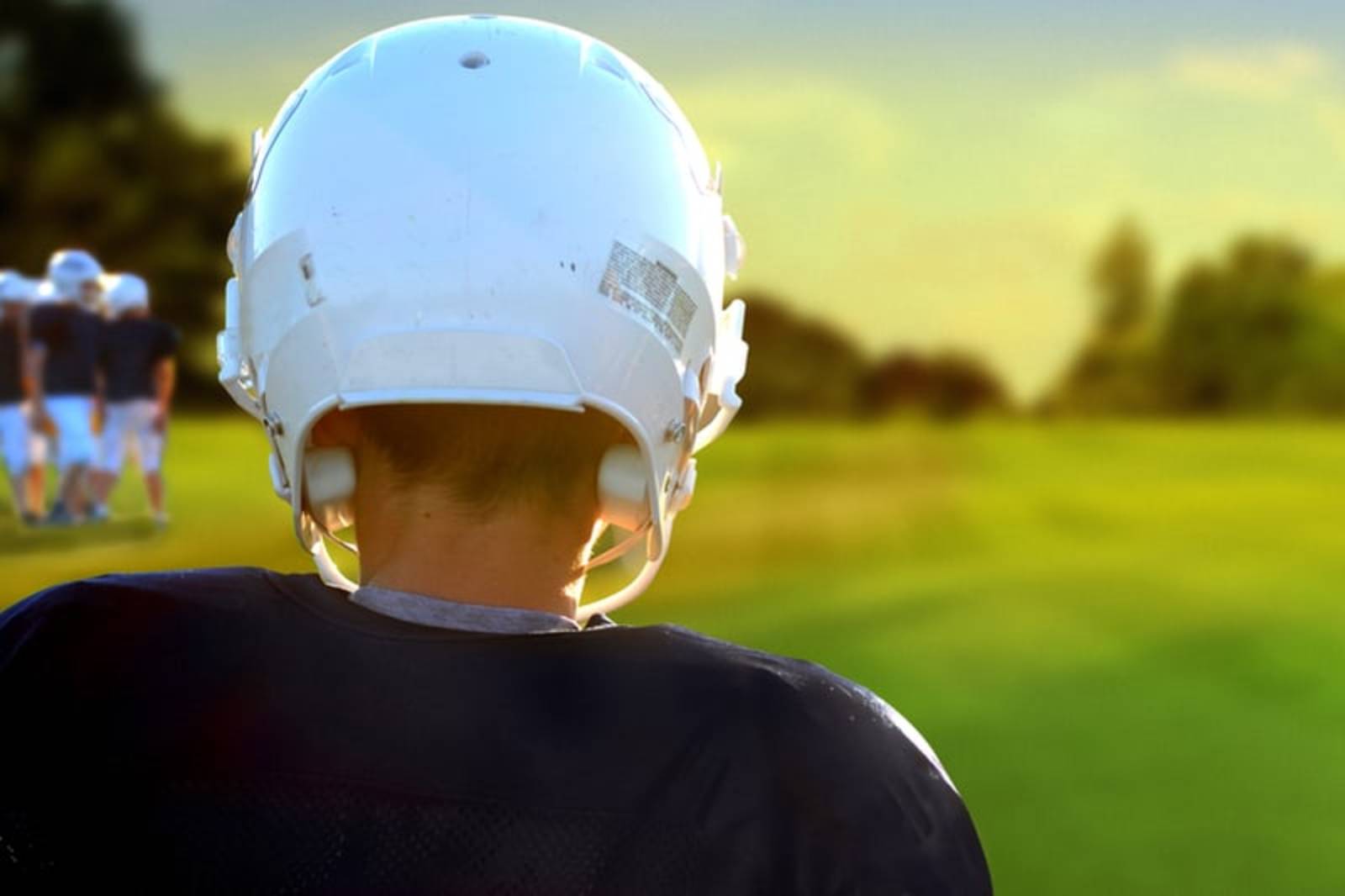 Man in football field wearing white helmet